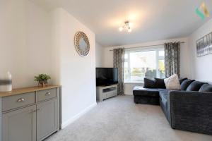 a living room with a couch and a tv at Aberdovey House TSAC in Stockton-on-Tees