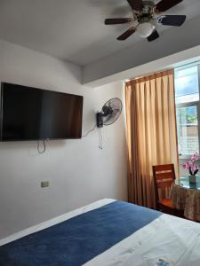 Schlafzimmer mit einem Bett, einem Deckenventilator und einem Fenster in der Unterkunft HOTEL WISMONT in La Merced