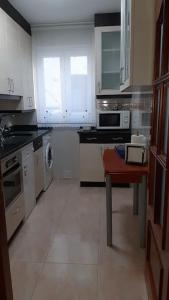 a kitchen with white appliances and a table in it at Santander centro in Santander