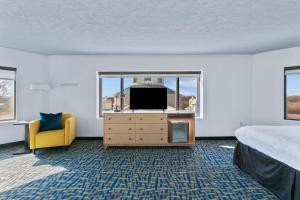 a bedroom with a bed and a tv and a window at Mulberry Vicksburg in Vicksburg