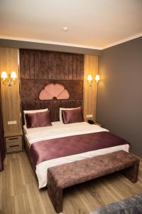 a bedroom with a large bed with a wooden headboard at Mandarinnart HOTEL in Astara