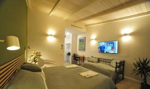 a bedroom with two beds and a couch and a tv at Tenuta Bussete Country Hotel in Viterbo