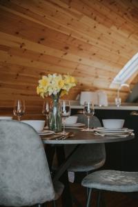 a table with chairs and a vase of yellow flowers at Bluebell in Rhayader