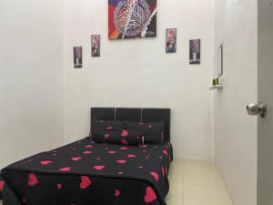 una camera da letto con un letto con cuori rosa sopra di Abg Long Fadhil Homestay a Sungai Petani