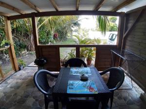 a patio with a table and chairs and a window at Hibiscus in Les Abymes
