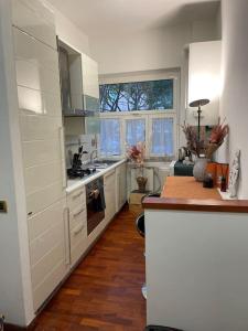 eine Küche mit weißen Schränken und Holzböden in der Unterkunft Appartamento a Roma ristrutturato in Rom
