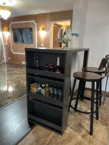 a black book shelf with a table and a stool at Sarah Relax 1 in Drobeta-Turnu Severin