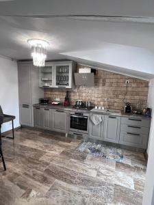 a kitchen with gray cabinets and a tile floor at Sarah Relax 1 in Drobeta-Turnu Severin