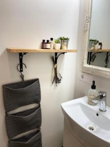 a bathroom with a shelf on the wall next to a sink at City center apartment in Liepāja