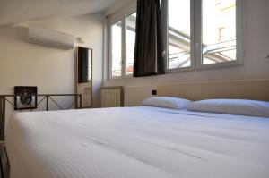 a bedroom with a large white bed with two pillows at Loft ristrutturato vicino M4 Argonne - San Benigno in Milan