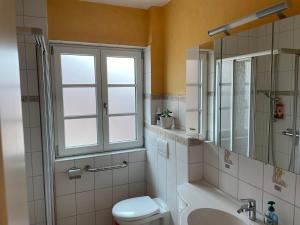 ein Bad mit einem WC, einem Waschbecken und einem Fenster in der Unterkunft Hus Finkwarder in Büsum