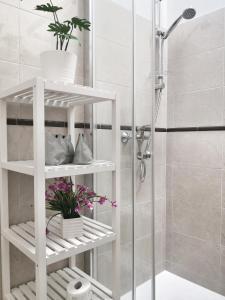 a white shelf in a bathroom with a shower at Loft ristrutturato vicino M4 Argonne - San Benigno in Milan