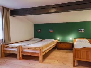 two beds in a room with green walls at DasBeckHaus - Chiemgau Karte in Inzell