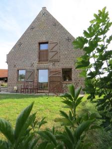a brick house with windows on a grass field at Holiday Home 't Hof der Witte Damen in Veurne