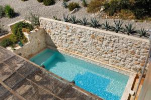 an overhead view of a swimming pool next to a stone wall at Villa Vito in Hvar