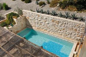 an overhead view of a swimming pool next to a stone wall at Villa Vito in Hvar