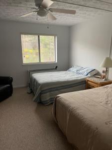 sypialnia z 2 łóżkami i wentylatorem sufitowym w obiekcie Lakeside Condo with plenty of amenities close to Bristol Mountain - permit - 2024-0018 w mieście Canandaigua