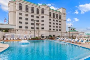 a hotel with a large swimming pool with lounge chairs at Mulberry Vicksburg in Vicksburg