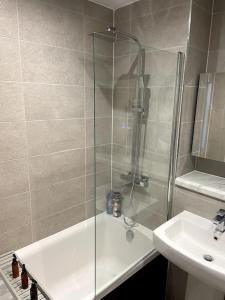 a shower with a glass door next to a sink at Luxury 1 bed full apartment with balcony in Liverpool