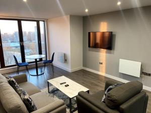 a living room with a couch and a table at Luxury 1 bed full apartment with balcony in Liverpool