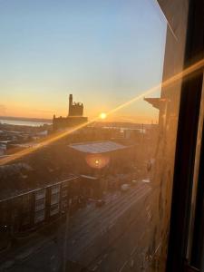 una ventana con vistas a la puesta de sol. en Luxury 1 bed full apartment with balcony, en Liverpool