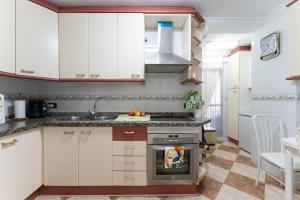 cocina con armarios blancos y fogones en MalagaSuite Sotomar Apartment, en Torremolinos