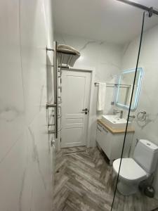 a white bathroom with a toilet and a sink at Apartments Pushkin Street in Yerevan