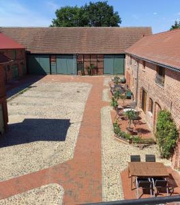 a brick building with a courtyard with tables and benches at Pension Claudia Güldenpfennig in Tangermünde