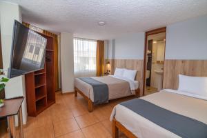 Habitación de hotel con 2 camas y TV de pantalla plana. en Casa Villa Arequipa, en Arequipa