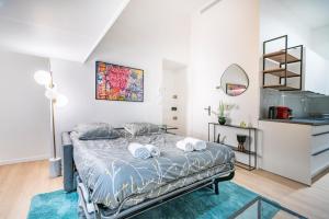 een slaapkamer met een bed met handdoeken erop bij Frontière Monaco - Appartement Luxe - Belle Epoque - AL in Beausoleil