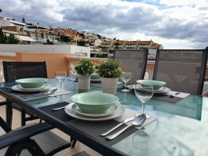 een tafel met borden en wijnglazen op een balkon bij Sea View in Paradise Court in Adeje