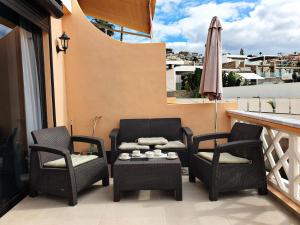 een patio met 2 stoelen, een tafel en een parasol bij Sea View in Paradise Court in Adeje