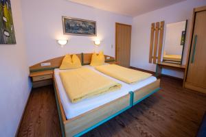 a bedroom with a large bed with yellow pillows at Apartment Bacher in Wald im Pinzgau