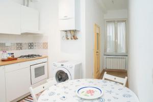 een keuken met een tafel en een wasmachine bij 057 - Casa Portobello, Centrale a 50 metri dal mare in Sestri Levante