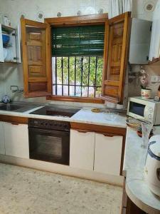 une cuisine avec une cuisinière et une fenêtre dans l'établissement Carmen de la Sultana, à Grenade