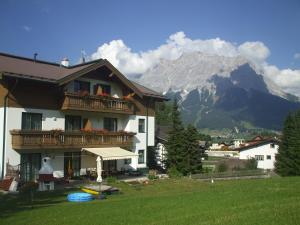 a house with a balcony with a mountain in the background at Haus Gipfelblick in Lermoos
