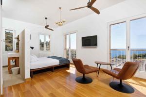 a bedroom with a bed and two chairs and a tv at Villa Vito in Hvar
