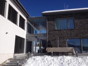 a house with a table in the snow in front of it at Glücksthaler by AA Holiday Homes - SchladmingDachstein in Aich