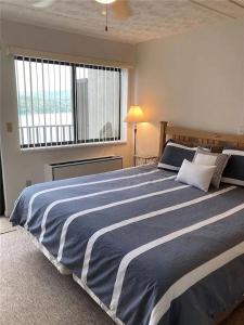 sypialnia z dużym niebiesko-białym łóżkiem w obiekcie Lakeside Condo with plenty of amenities close to Bristol Mountain - permit - 2024-0018 w mieście Canandaigua
