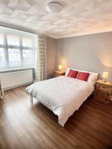1 dormitorio con 1 cama blanca grande con almohadas rojas en Richmond HOUSE, en Slough