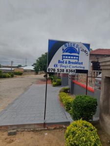 a sign for a bed and breakfast in front of a building at Nsuku Bed and Breakfast in Thulamahashi