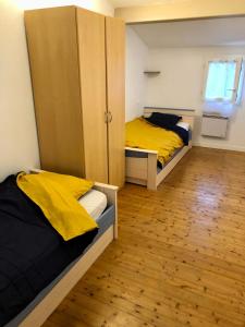 1 dormitorio con 2 camas, armario y suelo de madera en Petite Pause Oléronaise en La Cotinière