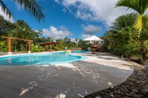 een zwembad in een resort met een palmboom bij Arenal History INN in Fortuna