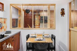 a kitchen with a table with chairs and a window at Gîte des 3 lutins in Eschbach-au-Val