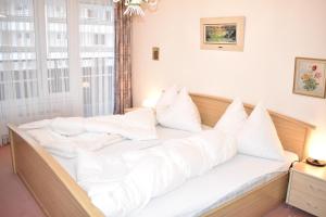 uma cama com almofadas brancas num quarto em Sotmirana 53 (316 Sh) em Lenzerheide