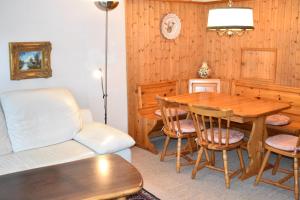 ein Wohnzimmer mit einem Tisch, Stühlen und einem Sofa in der Unterkunft Sursilvana 9 (315 Wa) in Lenzerheide