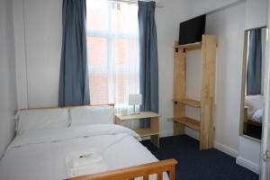 a bedroom with a white bed and a window at Churchill Hotel & Nagawa Restaurant in Coventry