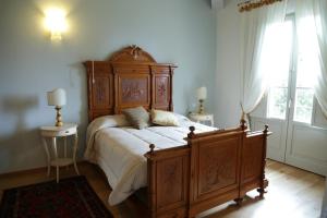 a bedroom with a large wooden bed and a window at B&B Il Canto del Gallo in Casole dʼElsa