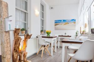 uma sala de jantar com cadeiras brancas e uma mesa em Haus Menno Janssen - Doppelzimmer em Norderney