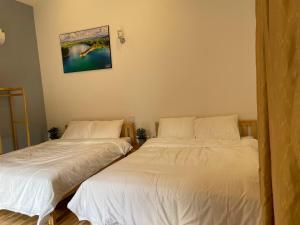 dwa łóżka siedzące obok siebie w sypialni w obiekcie Pleiku Homestay w mieście Pleiku